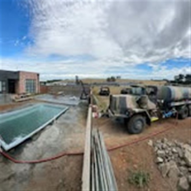 K.R water tanker at a construction site with hose run out