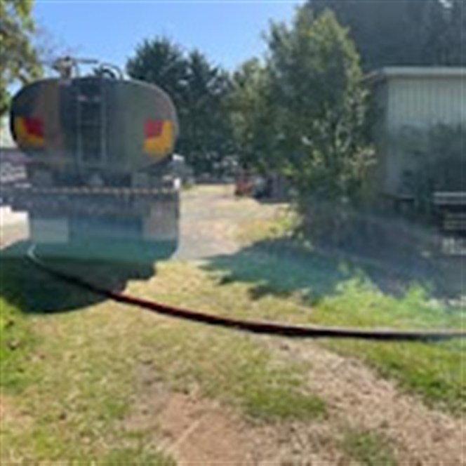 Rear of the K.R water tanker during a delivery, hose running out
